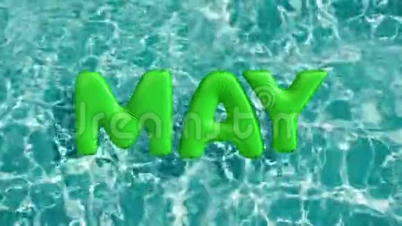 单词5月形状的充气游泳圈漂浮在清爽的蓝色游泳池视频的预览图