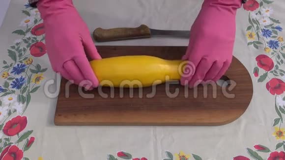 手与手套切割黄色西葫芦视频的预览图