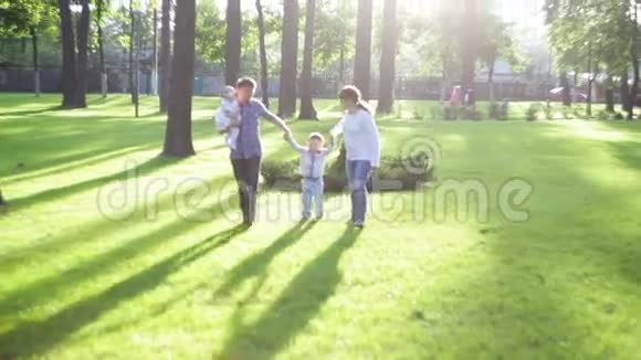 一家人在草地上的夏日公园散步视频的预览图