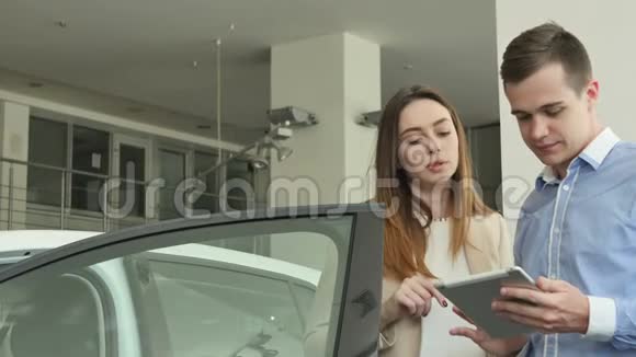 推销员和女人在汽车经销店谈论汽车视频的预览图