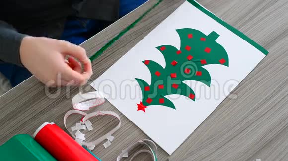 青少年男孩用彩色自粘纸制作圣诞卡视频的预览图