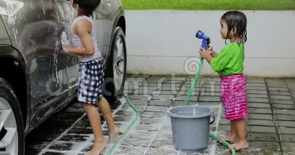 快乐的亚洲小朋友洗车视频的预览图