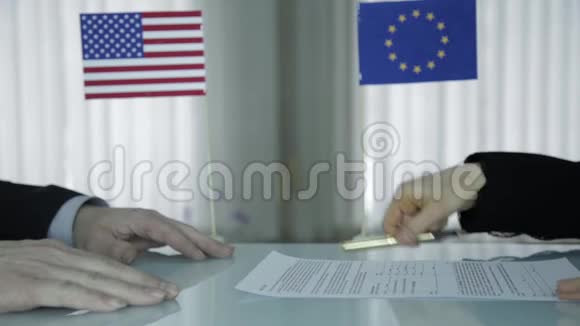 外国合作伙伴签署合同用钢笔特写女性手和男性手国际商人合作视频的预览图