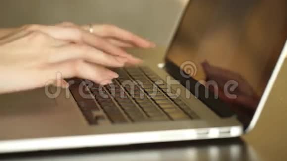 一只正忙着在笔记本电脑上打字的女性手视频的预览图