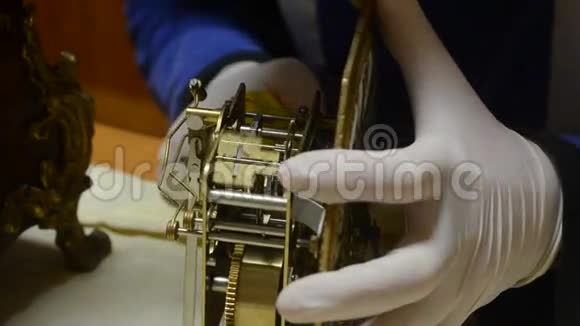 带白色手套的钟表匠对古董摆钟机械系统进行检修视频的预览图