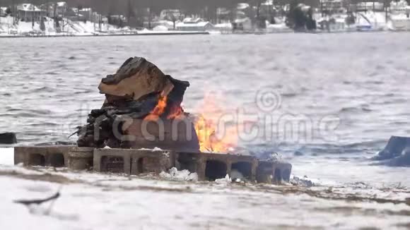 冬令营火沿雪湖岸前视频的预览图