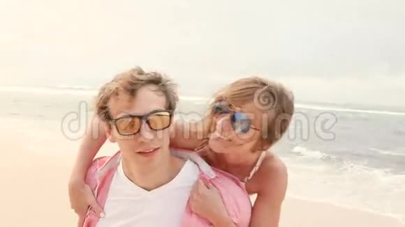 微笑的年轻夫妇驮在海滩上视频的预览图