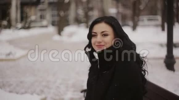 冬天公园里坐在长凳上的女人视频的预览图