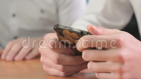 两名手持智能手机的男子的特写视频的预览图