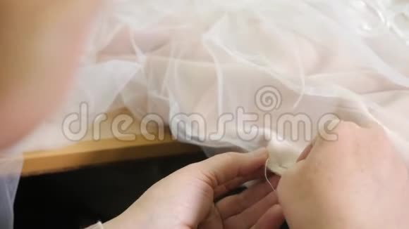 针线的特写刺绣图案缝制优雅婚纱的设备手工制作视频的预览图