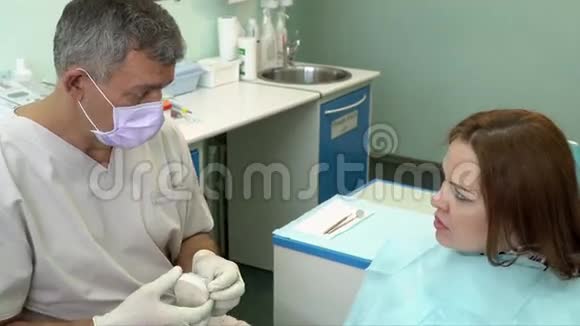 口腔医生在牙科诊所的办公室里和病人谈话视频的预览图