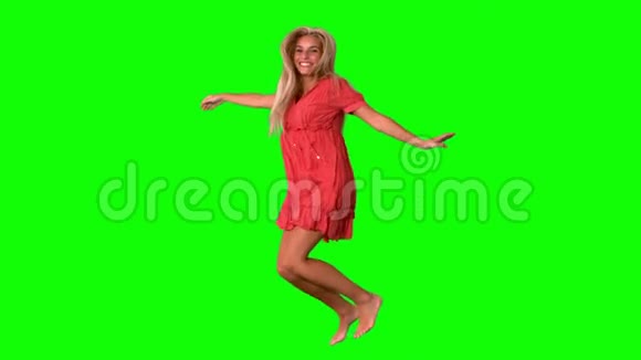 迷人的金发女郎在绿色屏幕上跳跃视频的预览图