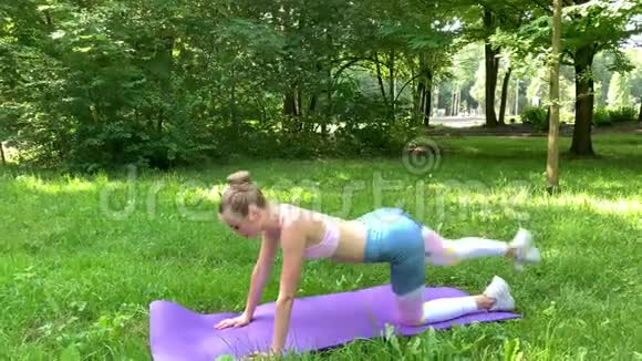 健身妇女在草坪上做运动视频的预览图