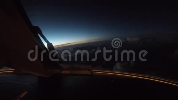 日落时飞机在云层上方飞行从驾驶舱看到的景色视频的预览图