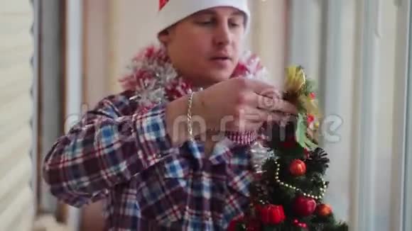男人穿着漂亮的小圣诞树视频的预览图
