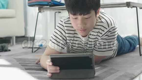 亚洲男孩在平板电脑上玩视频的预览图