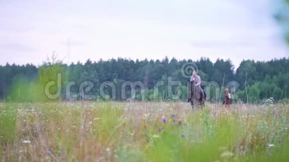 年轻的女子骑马驰骋在田野上视频的预览图