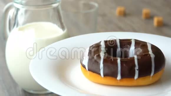 美味的甜圈巧克力糖霜旋转在盘子上粗糙的木桌失踪了视频的预览图