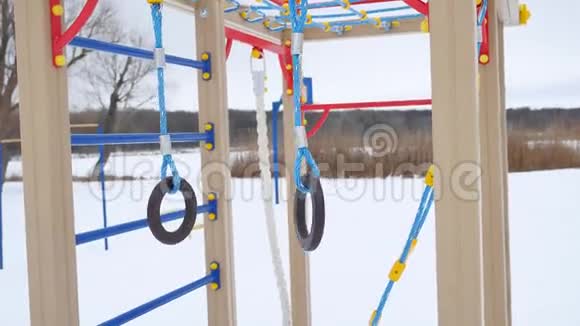儿童游乐场体操环摆动雪景一冬视频的预览图