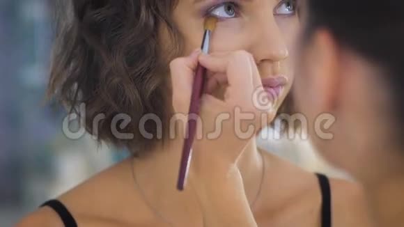 专业化妆师在年轻漂亮的脸上化妆摄影视频的预览图
