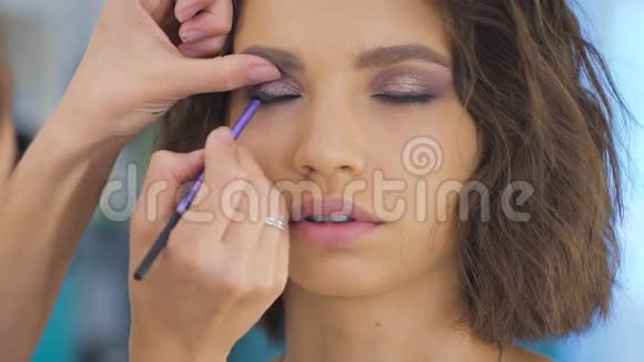 专业化妆师在年轻漂亮的脸上化妆摄影视频的预览图