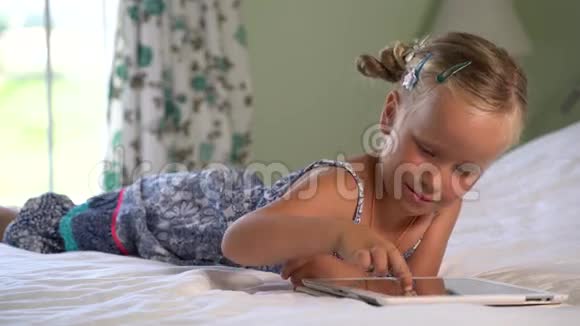 小可爱的女孩在平板电脑上玩游戏视频的预览图