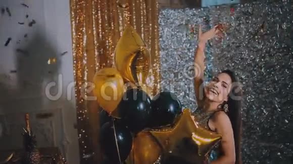 这个女孩正在金色背景上玩气球派对派对视频的预览图