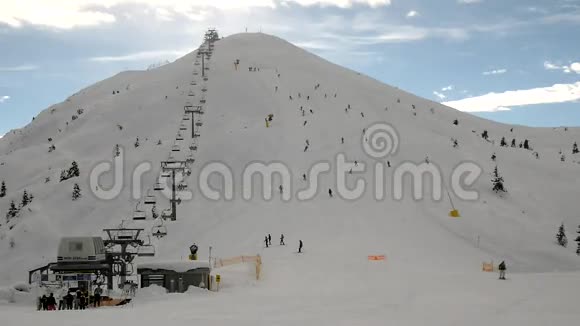 在滑雪场的山顶上用绳索行走一群滑雪者在斜坡上视频的预览图
