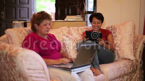母亲和女儿在家里一起使用平板电脑视频的预览图