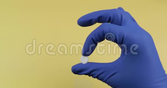 戴着橡胶无菌医疗手套的一颗白色圆丸视频的预览图