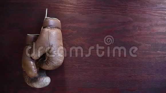 老式拳击手套挂在木制背景上视频的预览图