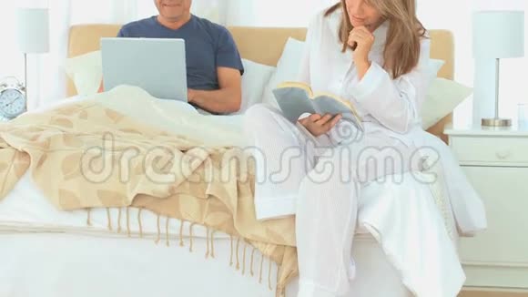 他妻子在看书的时候用笔记本电脑视频的预览图
