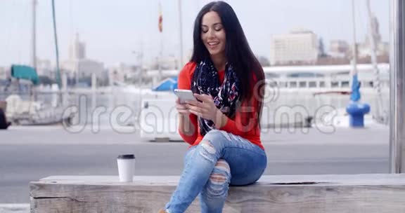 一位自信的年轻女子坐在手机上视频的预览图