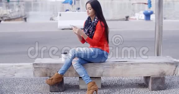 一位自信的年轻女子坐在手机上视频的预览图