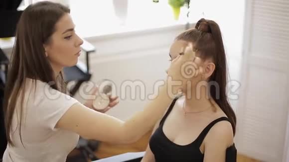 漂亮的化妆师涂口红手的化妆师画唇的年轻美女红头模特化妆视频的预览图