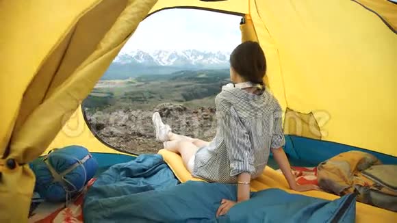 幸福的女人坐在帐篷里眺望群山视频的预览图