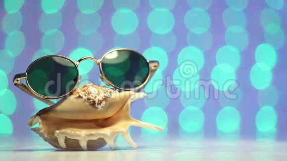 贝壳和太阳镜作为旅游概念在模糊的彩色背景下视频的预览图