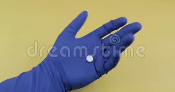 戴着橡胶无菌医疗手套的一颗白色圆丸视频的预览图