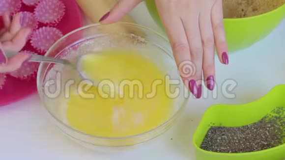 一个女人把可可粉滴入融化的黄油中混合为了做糖果视频的预览图