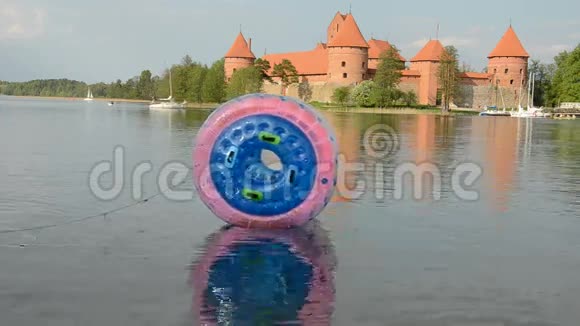 湖水上的塑料带球和特拉凯城堡视频的预览图
