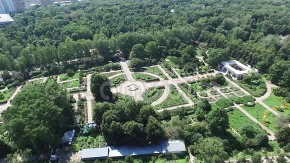 四架直升机拍摄美丽的绿色夏季花园与喷泉在中心晴天全景视频的预览图