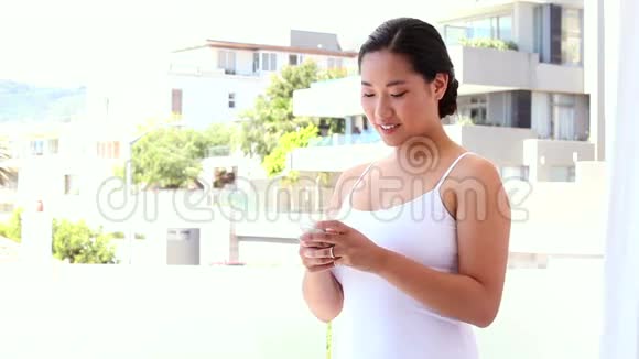 快乐的亚洲女人在手机上发短信视频的预览图