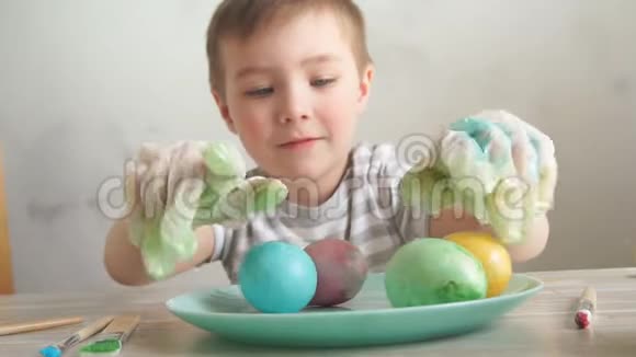 复活节庆祝概念快乐的小男孩装饰复活节彩蛋视频的预览图