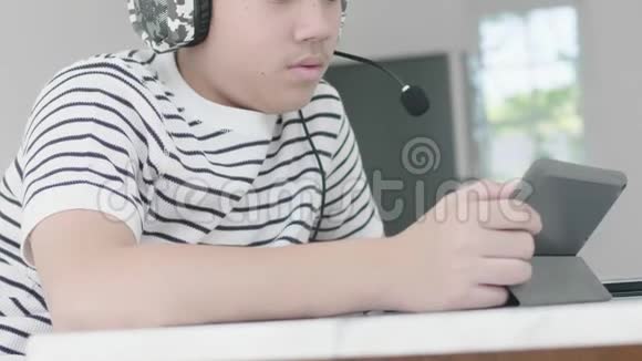 亚洲男孩在平板电脑上玩视频的预览图