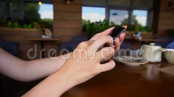 在餐厅用智能手机关闭女性的手视频的预览图