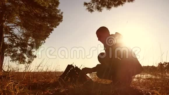 一个人正在准备篝火从树枝上点燃阳光童军Kindle篝火露营视频的预览图