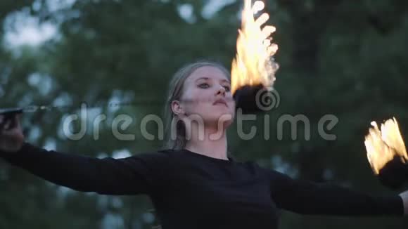 自信的女人在森林或公园里用火焰表演节目熟练的射击艺术家表现出对视频的预览图