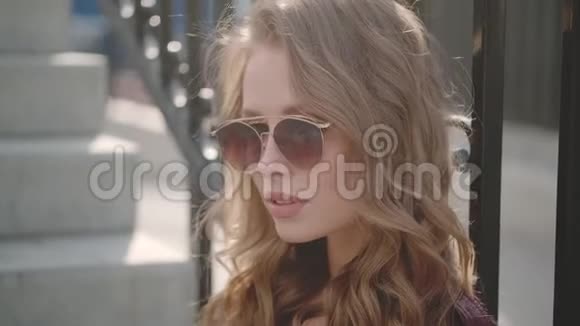 戴太阳镜的年轻漂亮女孩的特写照片视频的预览图