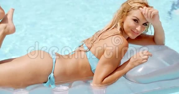 躺在游泳池里的漂浮床垫上的女人视频的预览图