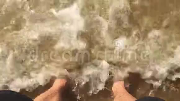 海洋慢动作视频一位男游客站在水溅到他脚上的海洋里视频的预览图